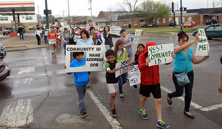 A group of people marching for community ID policies in their community